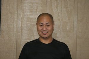A man in a black shirt smiling